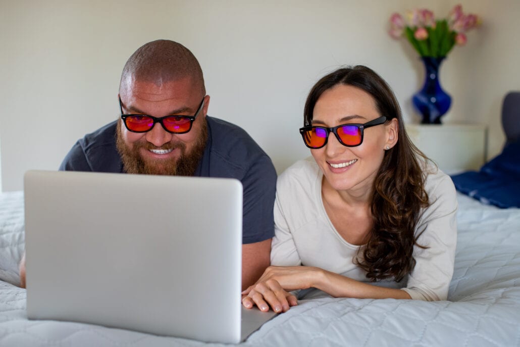 Paar mit Blaulichtfilter-Brillen am Laptop
