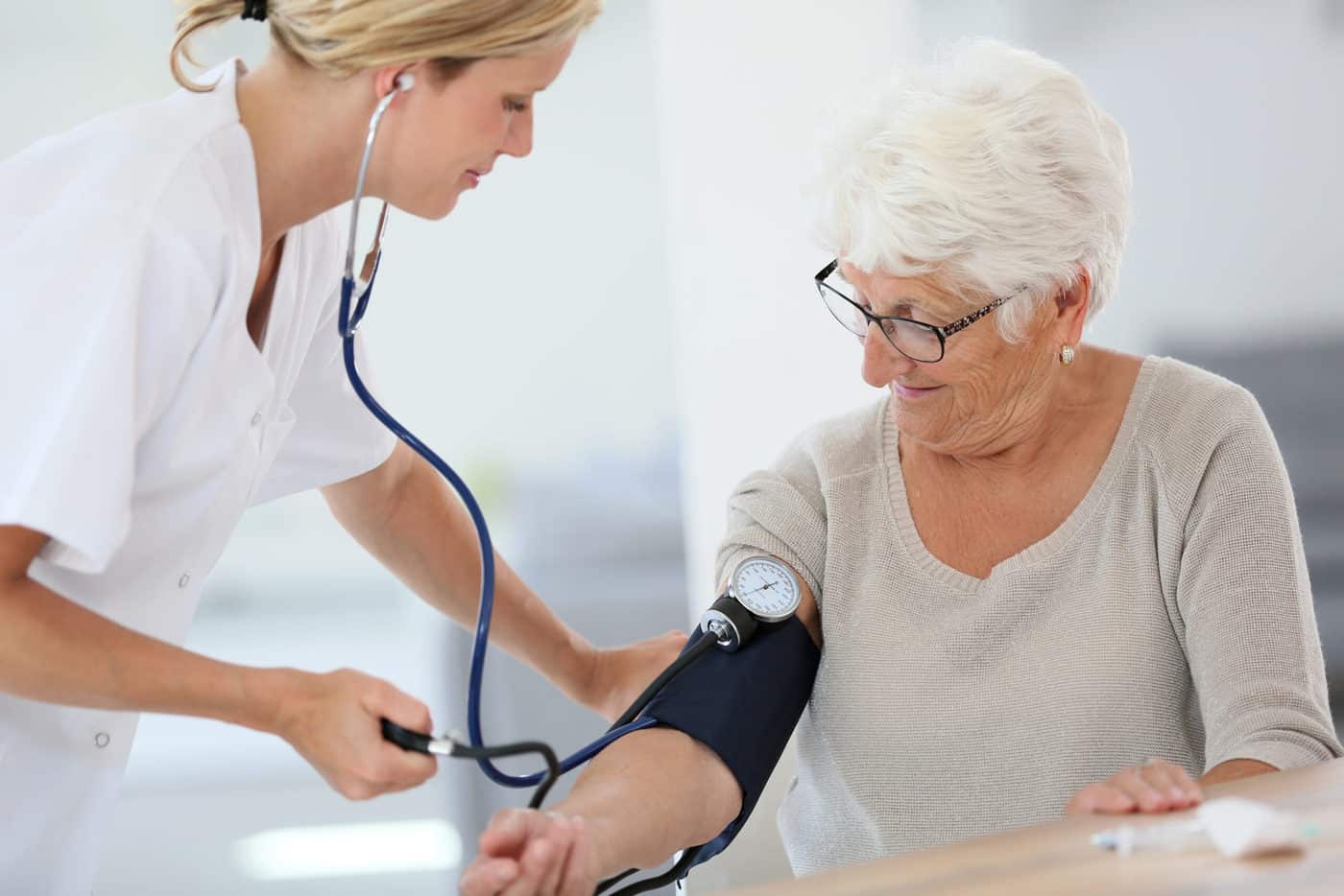 Pflegerin misst Blutdruck bei älterer Dame