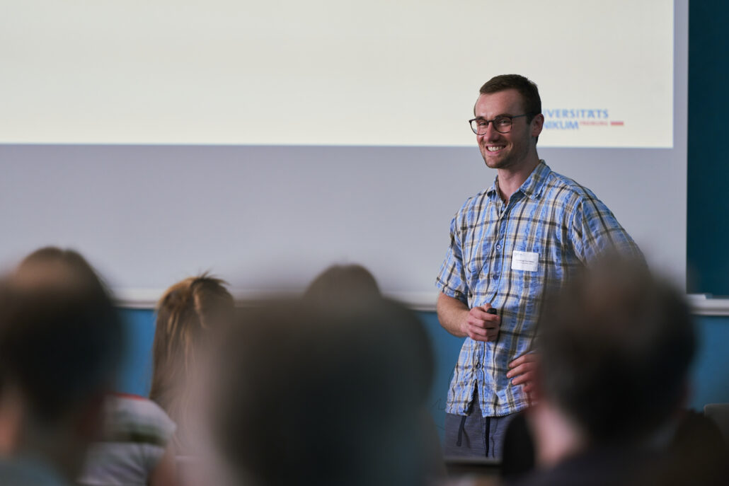 Dr. Waldemar Siemens steht während seines Vortrags beim Methodenforum lächelnd vor den Teilnehmer*innen. Foto: CDS