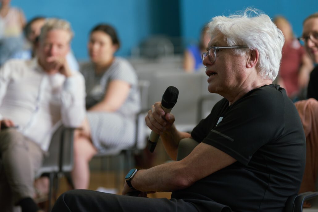 Prof. Dr. Georg Schmidt spricht bei einer Fragerunde während des Methodenforums in ein Mikrofon. Im Hintergrund sitzen Zuhörer*innen. Foto: CDS