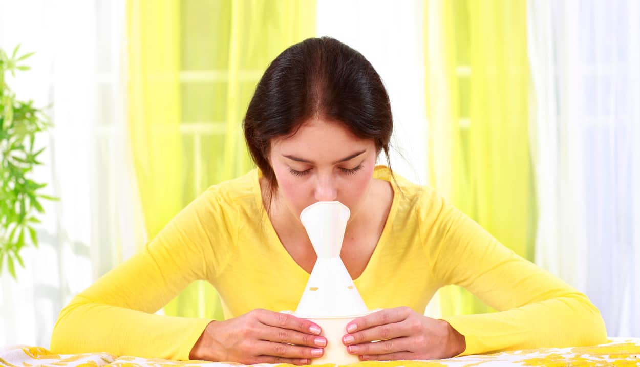 Frau mit Erkältung beim inhalieren