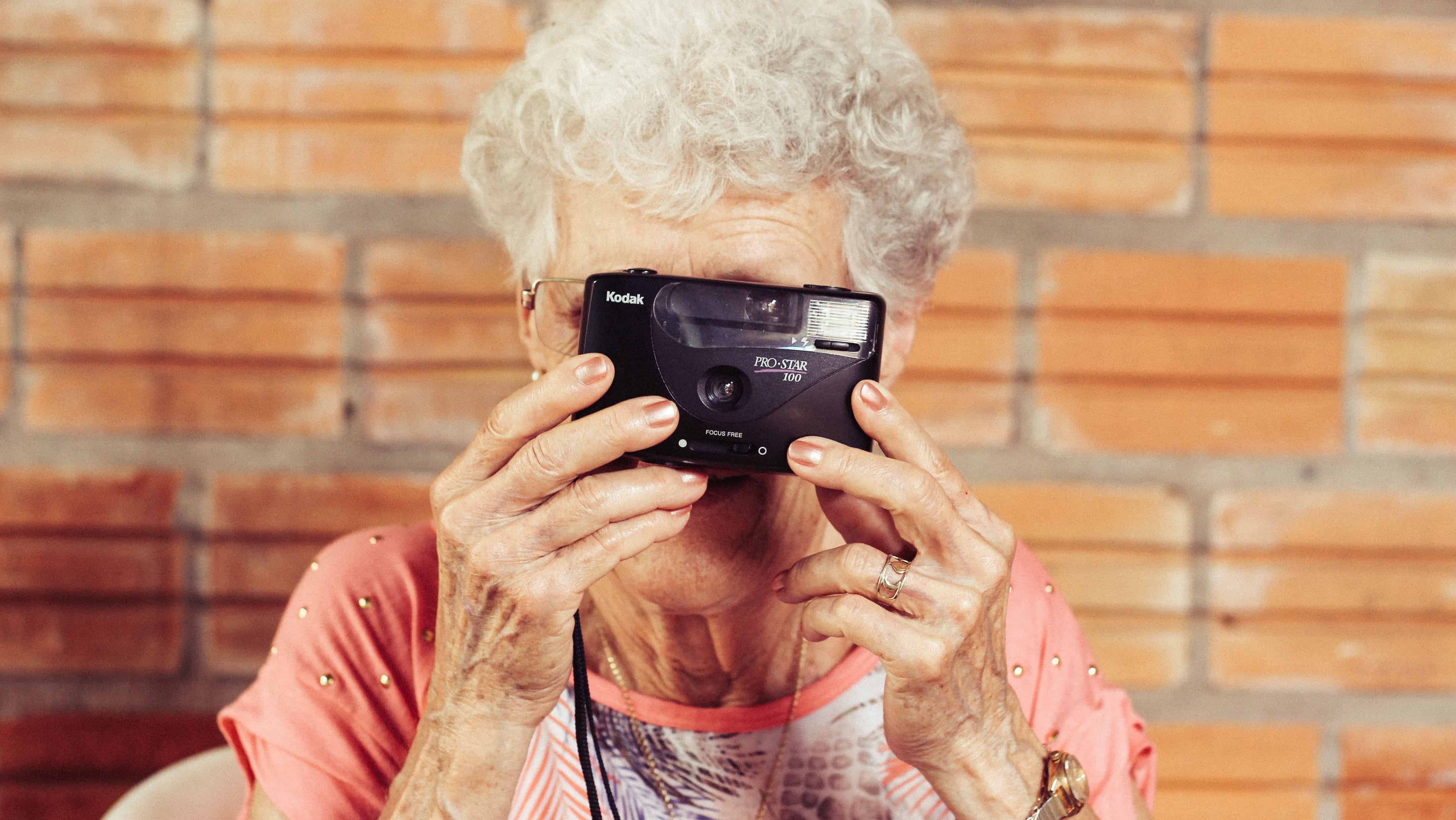 Ältere Frau schaut durch Kamera