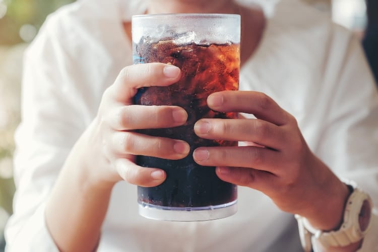 Woman hand giving glass ,Soft drinks with ice